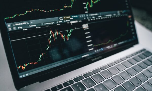 Black and Silver Laptop with Stock Market Display on Screen