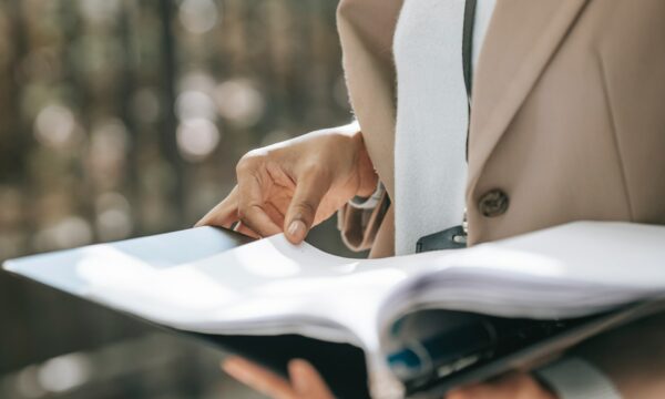 Crop businesswoman looking through documents